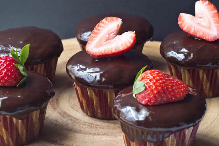 Strawberry Cupcakes - Sweet strawberry cupcakes are covered in chocolate ganache for a dessert inspired by the classic confection.