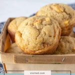 A small basket filled with several peach muffins. The text on the image reads "stetted.com peach muffins," highlighting these delicious homemade peach muffins.