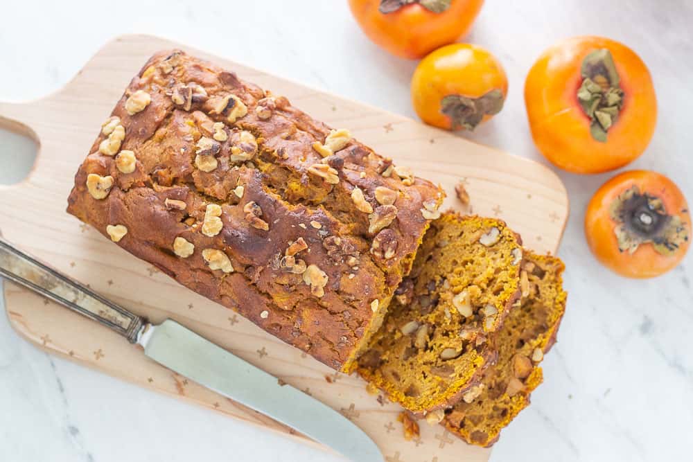 Pumpkin persimmon bread sliced overhead with knife