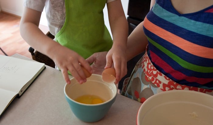 mom and child cracking eggs