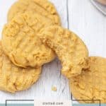 A stack of peanut butter cookies sits on a white surface, with one partially eaten to reveal its soft texture. Text overlay reads "peanut butter cookies," highlighting these classic treats.