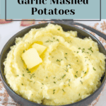 Garlic mashed potatoes in a bowl with butter and blueberry.