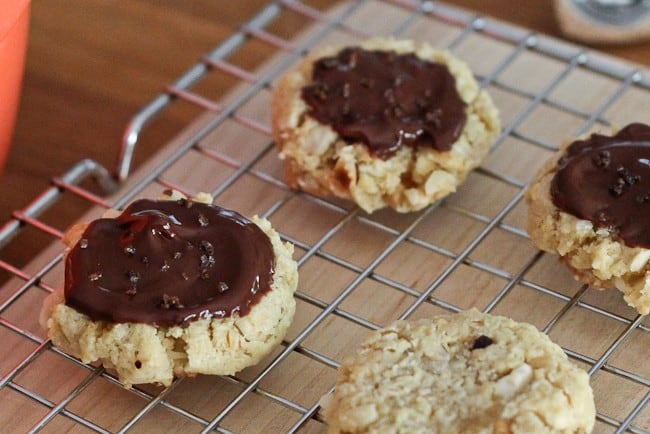 Chocolate Hazelnut Cookies - Reminiscent of pecan sandies, these hazelnut-studded cookies are topped with chocolate ganache before being finished with espresso salt.