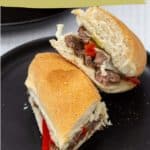 A steak & cheese sandwich cut in half on a black plate, filled with tender steak, melted cheese, and red peppers. Text overlay reads "steak & cheese sandwiches.