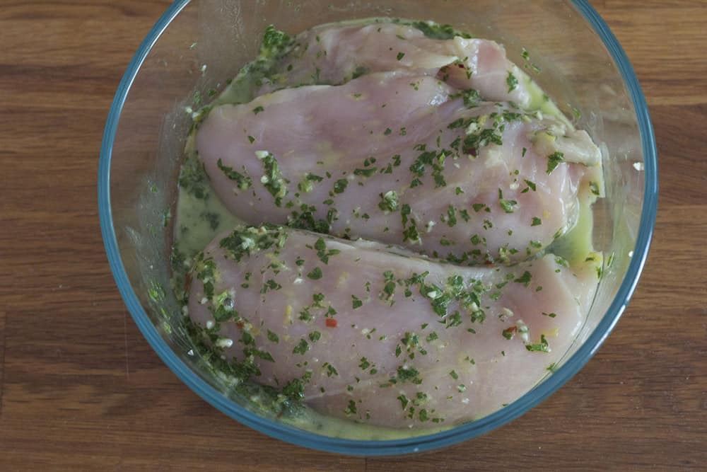 chicken marinading in chimichurri sauce