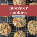 Overhead view of monster cookies with colorful candy pieces on a cooling rack, with text overlay reading "monster cookies.