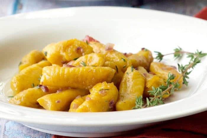 Pumpkin Gnocchi is tossed with a sauce of butter, shallots, bacon, and fresh herbs.