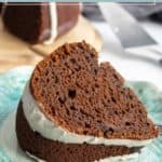 A slice of chocolate pumpkin bundt cake with white icing sits on a blue patterned plate, showcasing the rich flavors and inviting texture of this seasonal treat.
