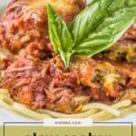 Enjoy tender slow cooker eggplant parmesan, topped with rich tomato sauce, melted cheese, and fresh basil, served on a bed of spaghetti for a comforting Italian-inspired meal.