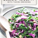 A bowl of kale slaw with tahini dressing, garnished with sesame seeds and beer and pretzel cupcakes, presented on a table with a fork on the side.