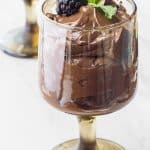 Two glasses of avocado mousse with blackberries and mint.