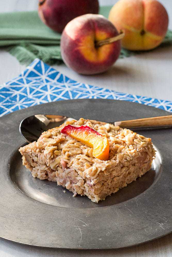 baked peach oatmeal slice on a silver plate