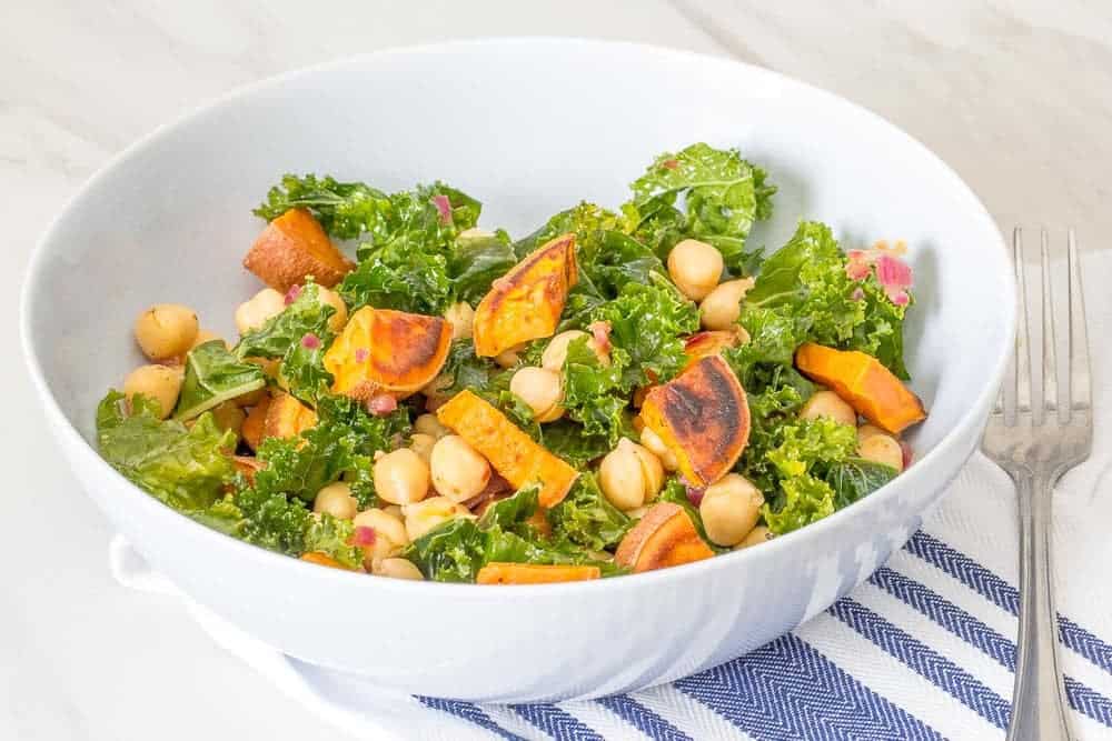 A sweet potato salad in a bowl with kale and chickpeas.