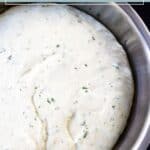 A bowl of risen herb pizza dough with visible green herb flecks, labeled "fresh herb pizza dough.
