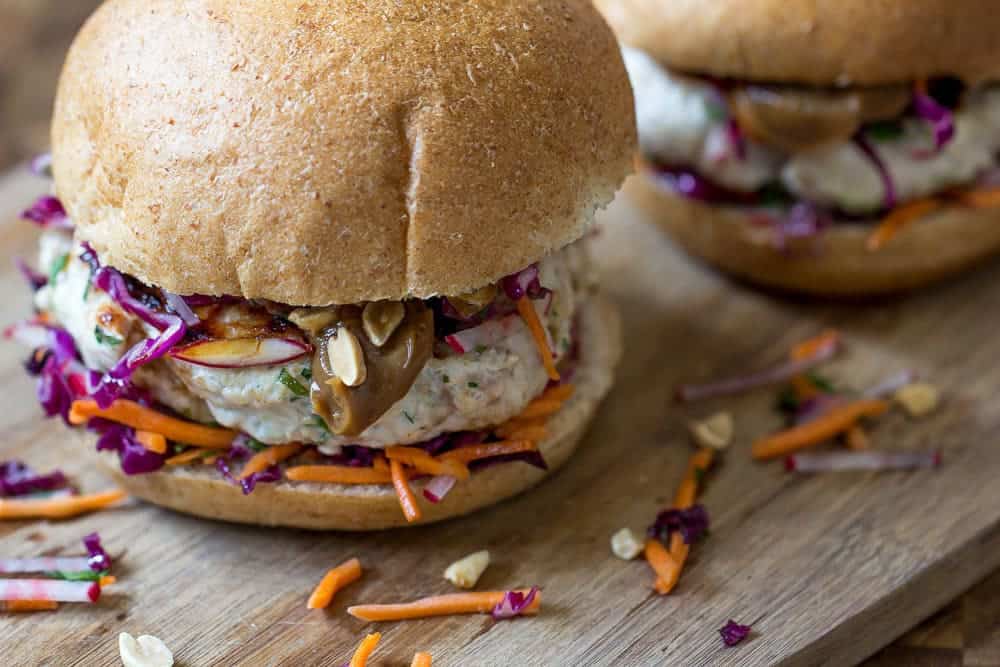 Thai peanut chicken burgers feature fresh herbs, crunchy veggies, and spicy-salty peanut sauce!