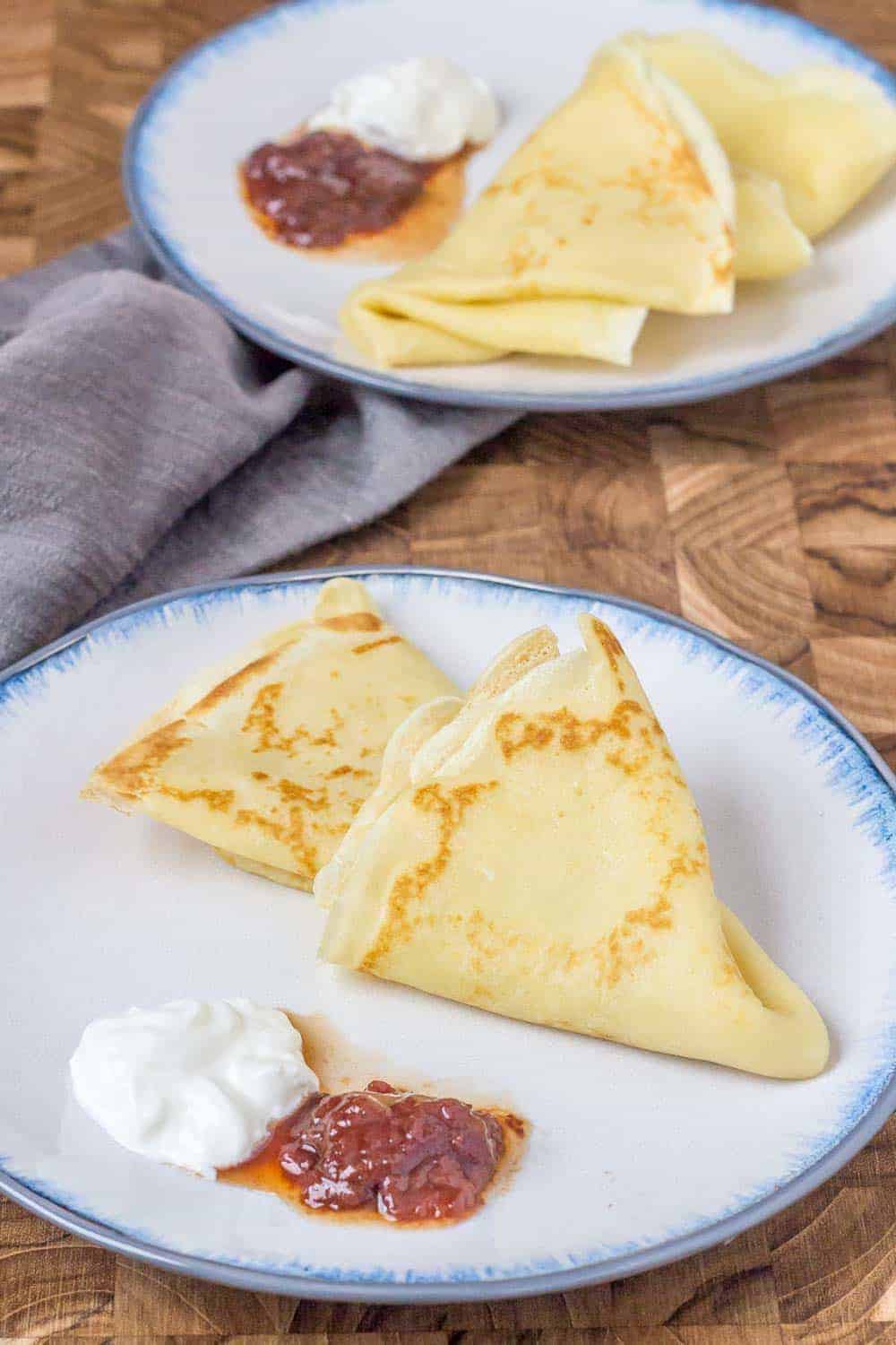 Russian crepes are thin pancakes that are served with sour cream and jam. It's a great breakfast!