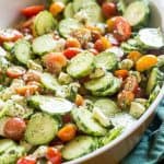 Cucumber tomato salad has fresh pesto as the dressing for a dish full of summer garden flavor.