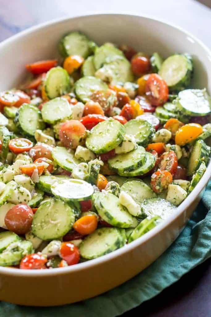 Cucumber tomato salad has fresh pesto as the dressing for a dish full of summer garden flavor.