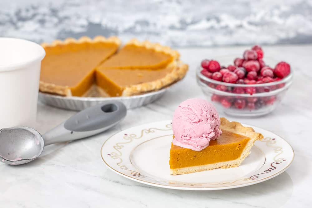 pumpkin pie, cranberries, and a slice of pie with cranberry ice cream on top