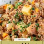 A close-up of savory bison picadillo with diced potatoes, carrots, and onions, all garnished with chopped parsley in a white bowl.