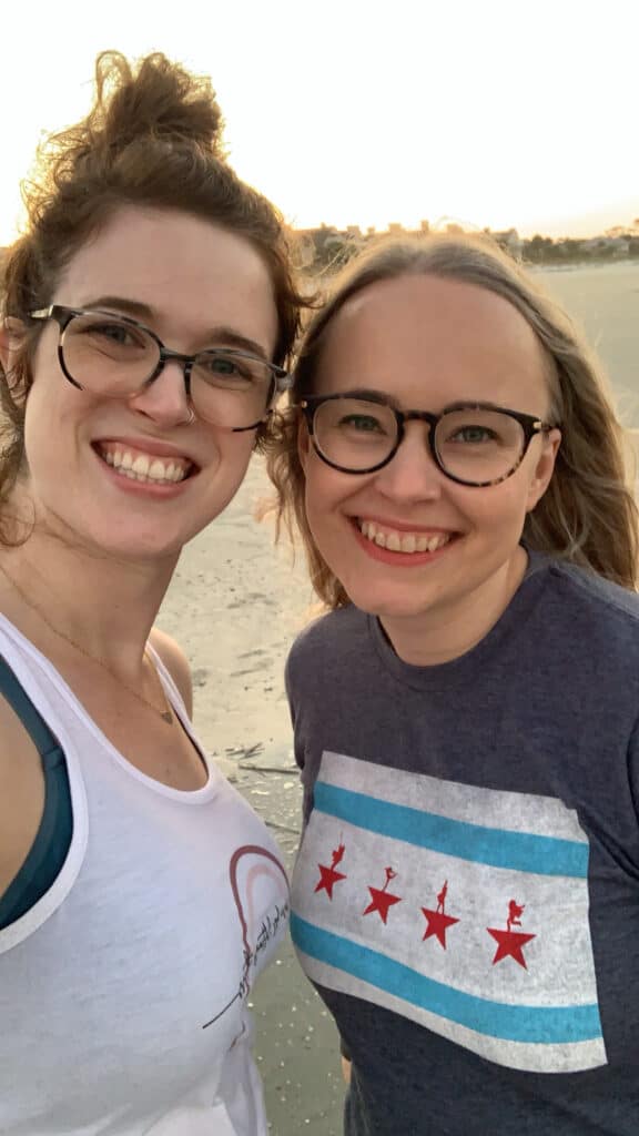 Hosts of I'd Rather Stay In podcast on a beach