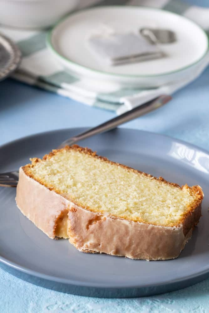 slice of cardamom cake with fork on grey plate