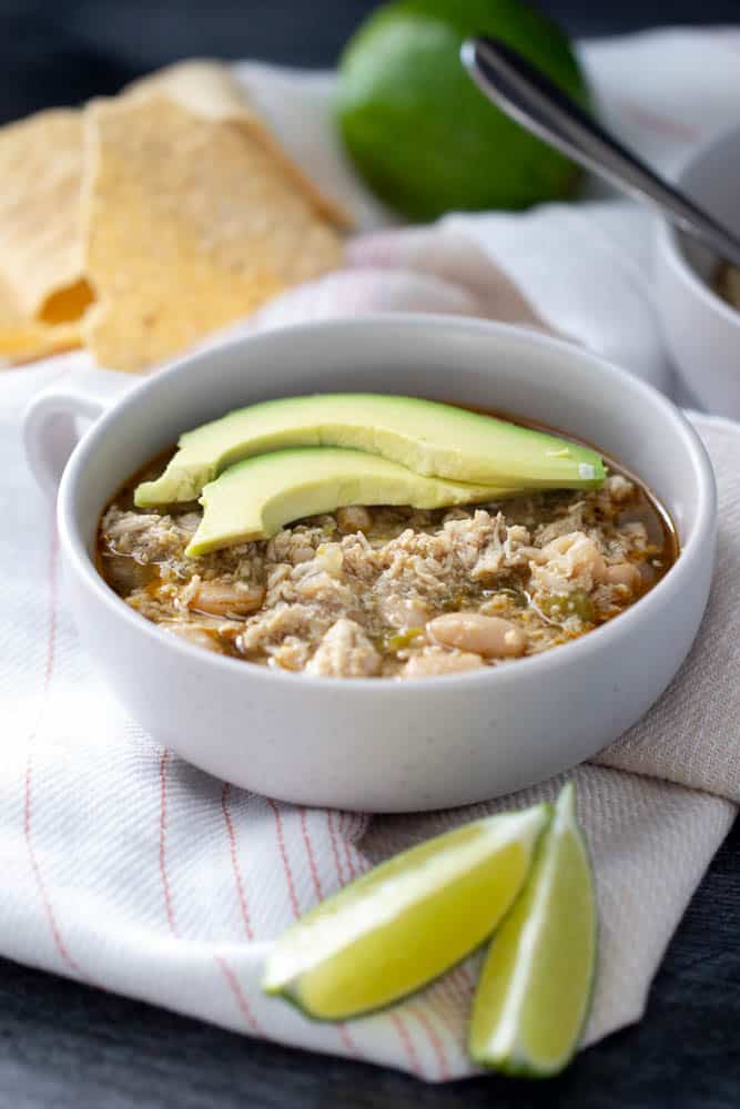 white bean chicken chili with avocado and lime in a bowl