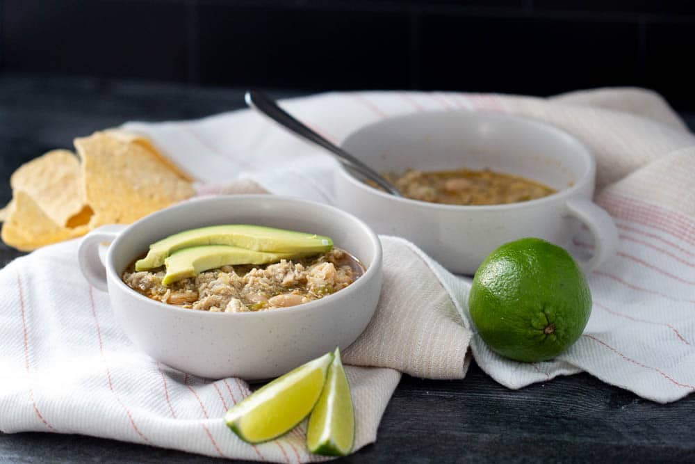 white bean chicken chili in two bowls with garnishes