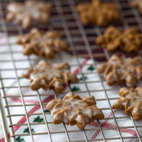 iced snowflake gingerbread spritz cookies on a cooling rack