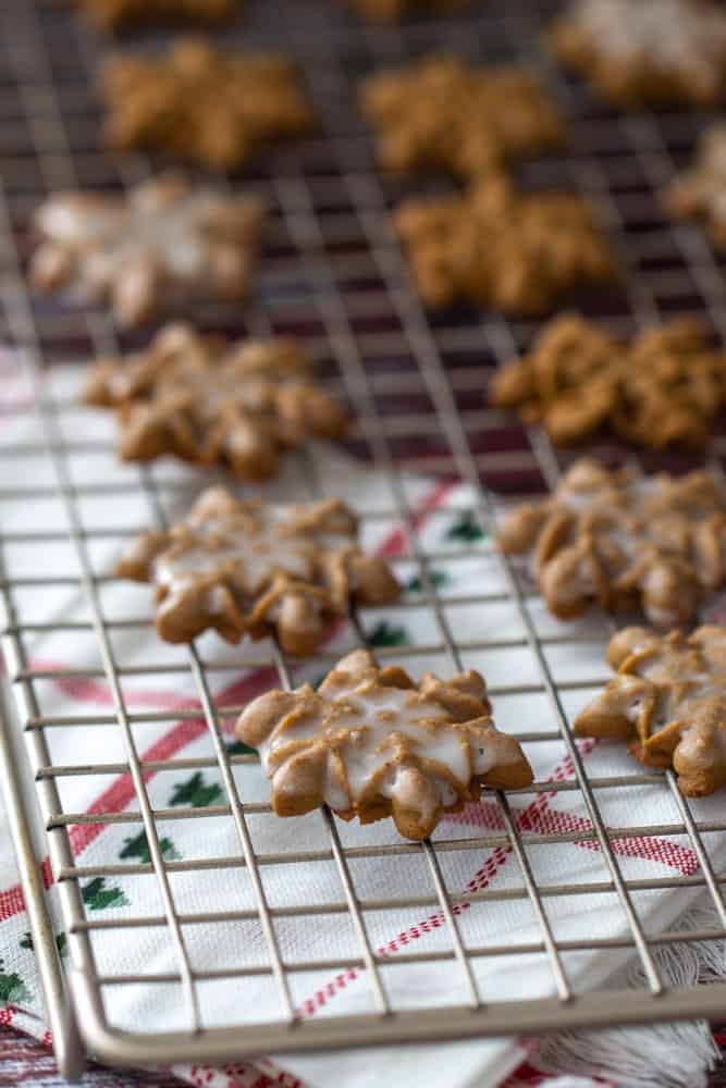 iced snowflake gingerbread spritz cookies on a cooling rack