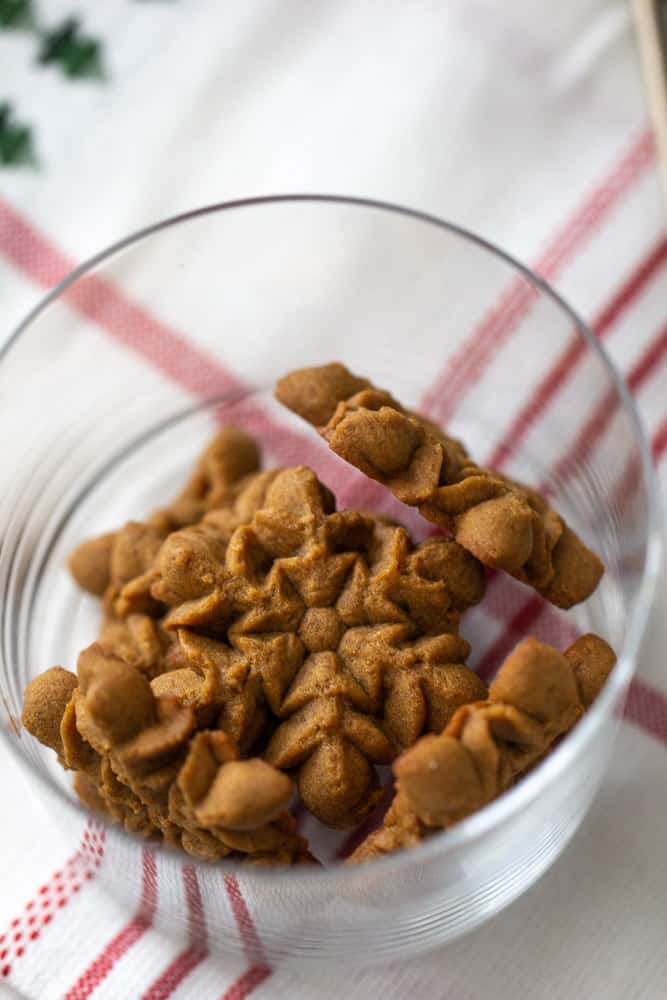 overhead of snowflake gingerbread spritz cookies in a glass