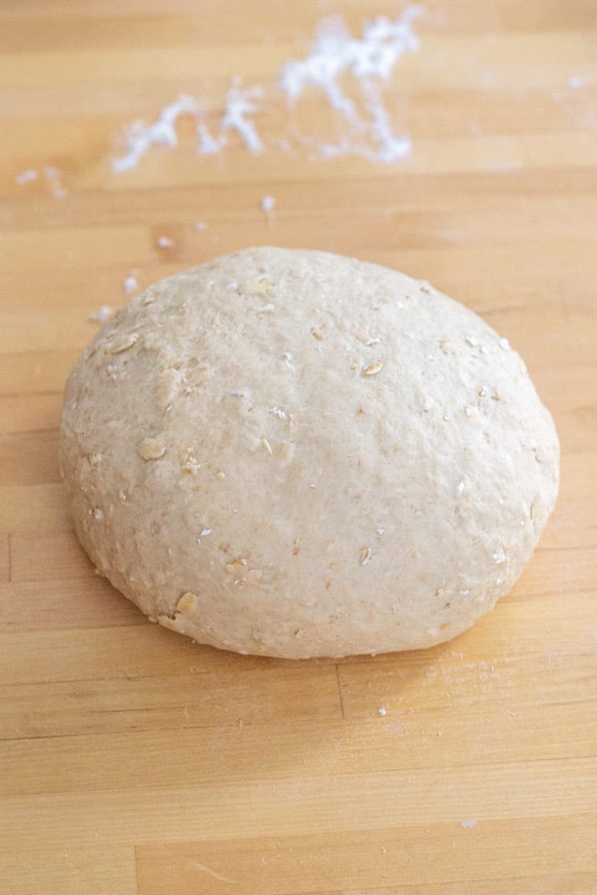 honey oatmeal bread dough on a wooden countertop