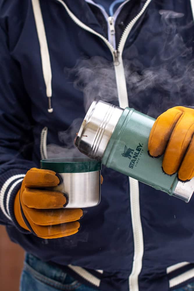 man in winter clothes pouring from Stanley food jar