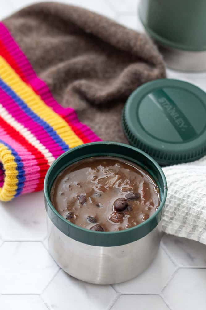 black bean soup in stanley food jar with colorful wool hat behind