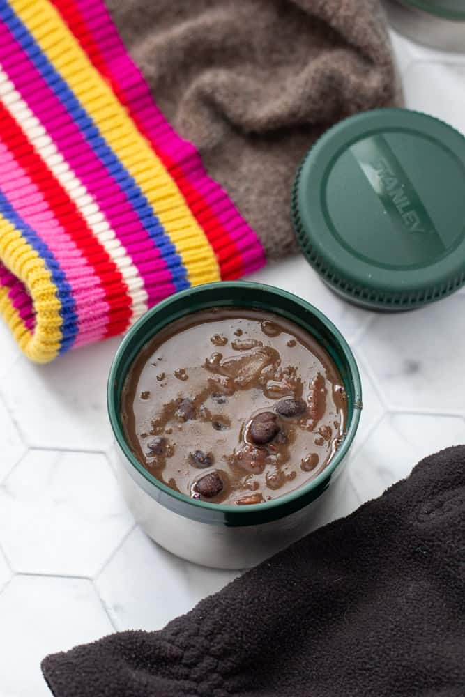 black bean soup in stanley food jar overhead, with winter gear beside