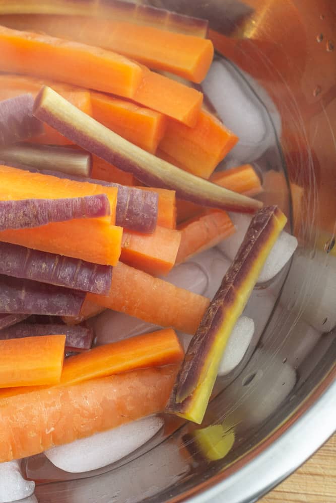 sliced carrots in a bowl filled with ice water