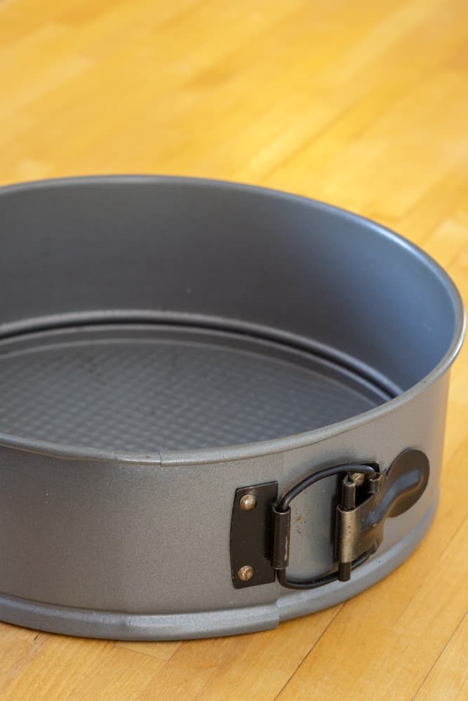 A springform pan on wooden counter.