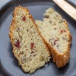 close up of cranberry soda bread slices on a black plate