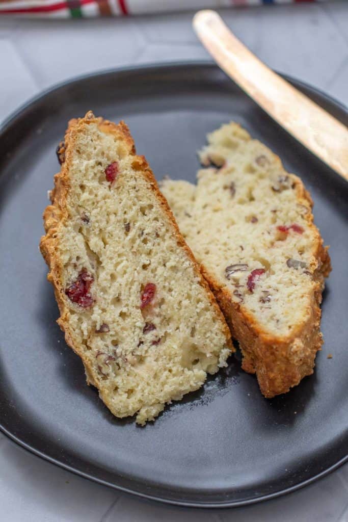 close up of cranberry soda bread slices on a black plate