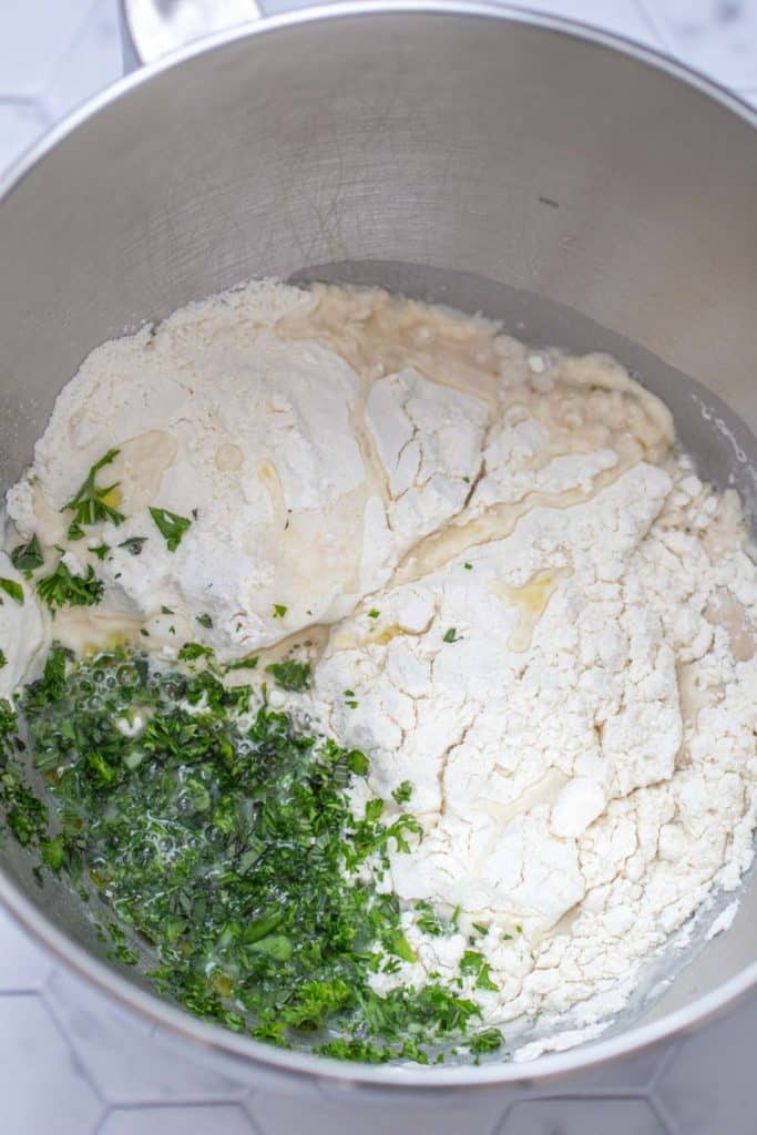 herb pizza dough ingredients in a metal bowl