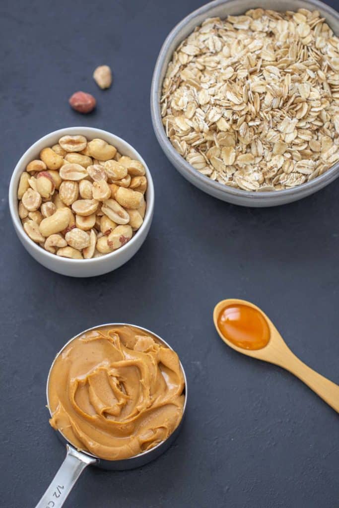 ingredients for peanut butter granola on a black background