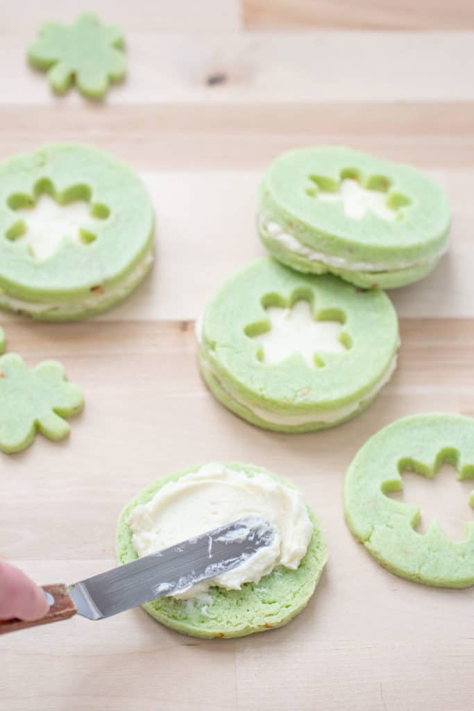 buttercream being spread onto pistachio pudding cookie