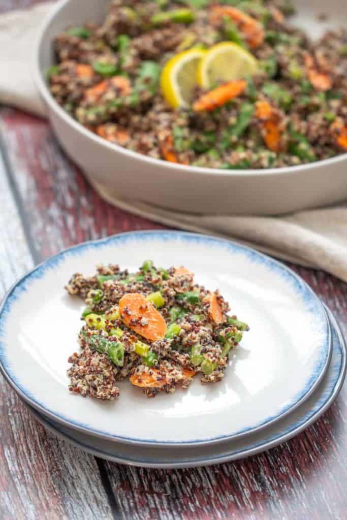 plate of quinoa primavera with serving dish behind