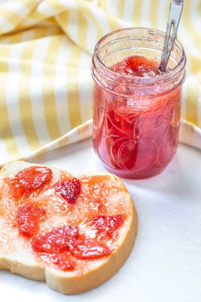 strawberry vanilla jam on toast with a jar behind