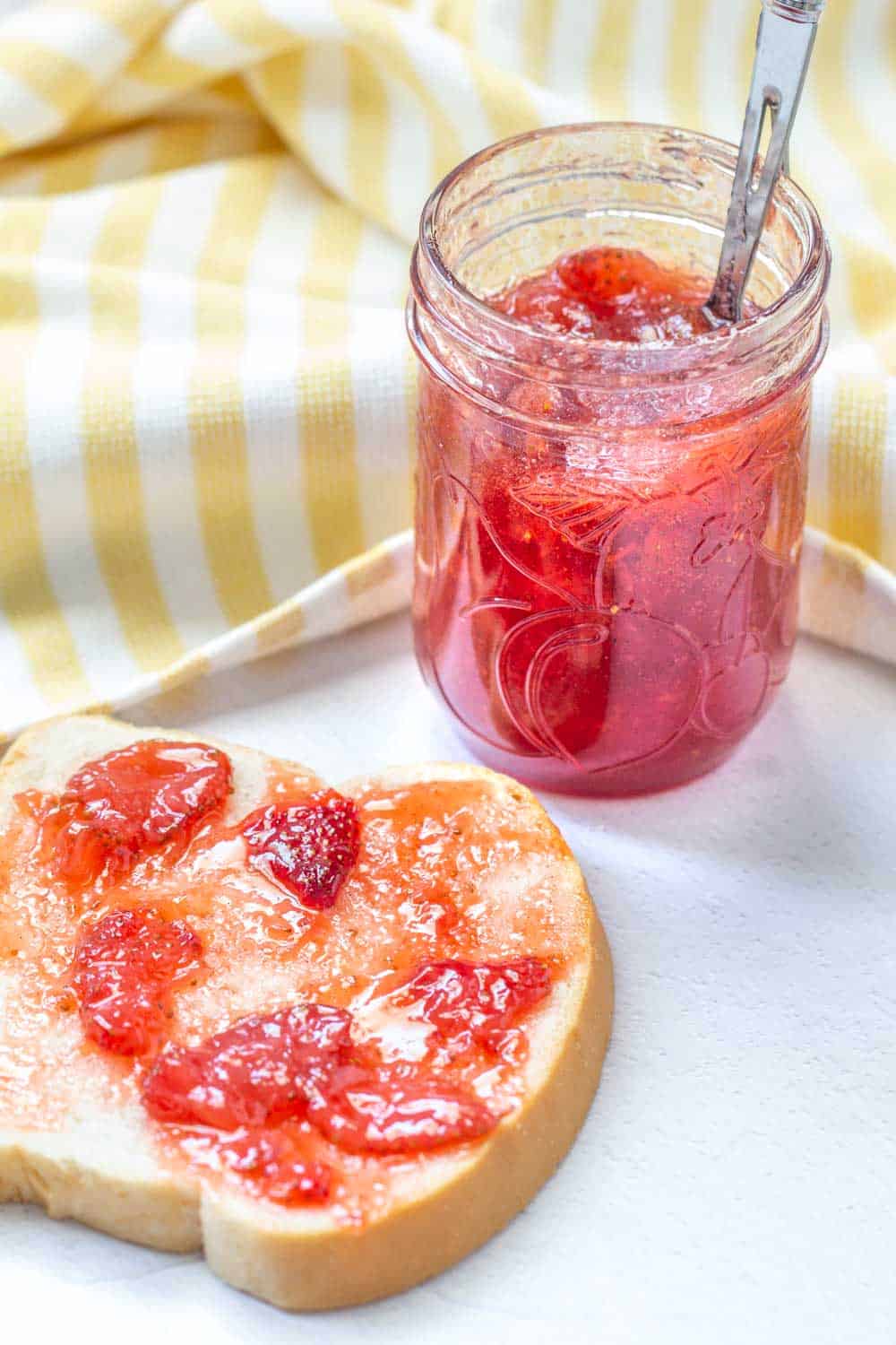 strawberry vanilla jam on toast with a jar behind