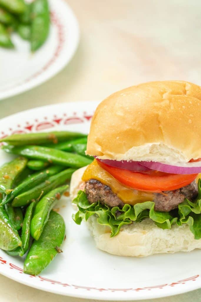 ground bison burger served with snap peas