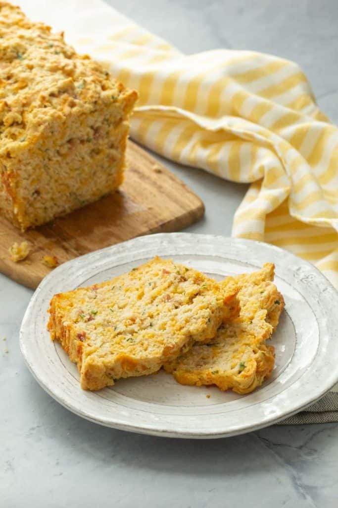 slices of beer bread on a plate with a striped yellow kitchen towel