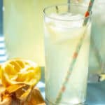 glasses of lemonade with paper straws and a citrus reamer beside