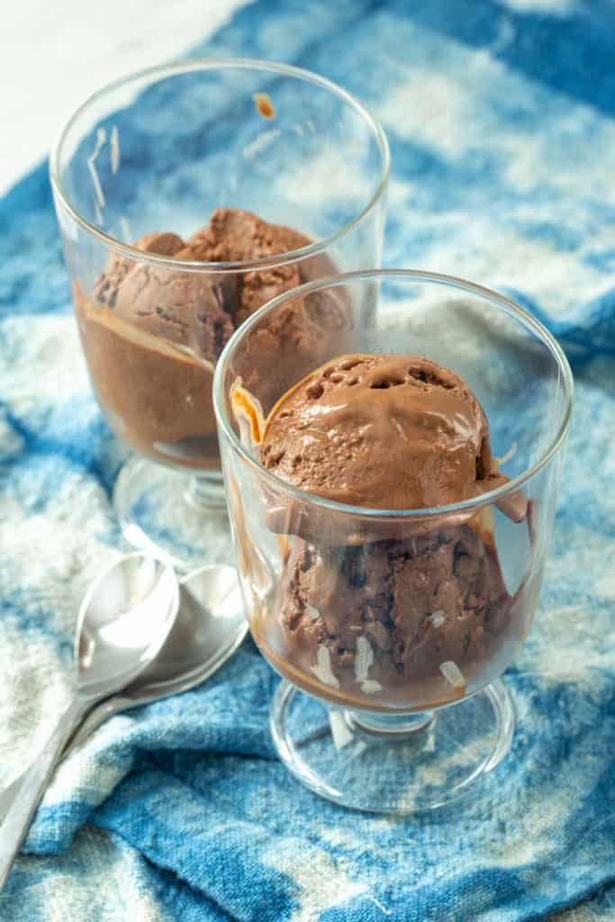 chocolate frozen yogurt in glass bowls on a blue fabric