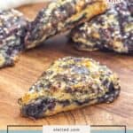 Close-up of fresh black raspberry scones on a wooden surface, sugar sprinkled on top. A badge in the corner reads "Real Recipes Real Kitchens." Text below highlights these irresistible black raspberry scones.